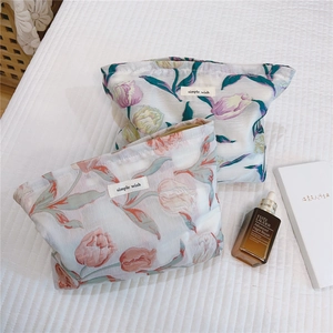 Détail de trousses à maquillage en jacquard de tulipes avec fermetures éclair dorées