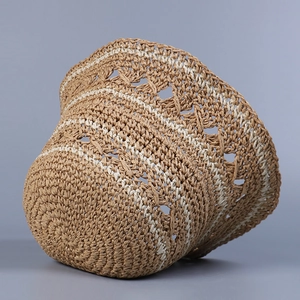 Close-up of khaki hand-woven straw sun hat showing hollow breathable texture and white stripes