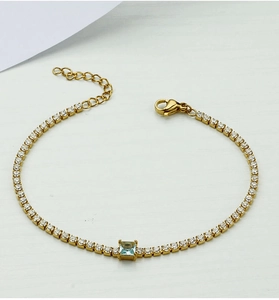 Close-up of gold titanium steel bracelet with white zircons and square sky blue stone