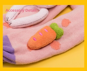 Macro detail of pink knitted scarf with 3D carrot plush and white fuzzy accents