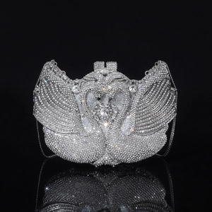 Detailed view of silver swan evening clutch with sparkling rhinestones on black background