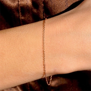 Macro shot of gold-plated layered stainless steel chain bracelet on woman's wrist