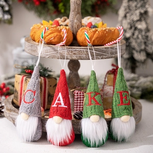 Detail of four Christmas gnomes with knitted hats embroidered with letters CAKE on a stand