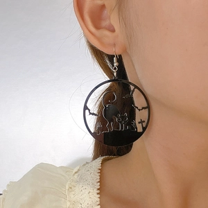 Detail of acrylic Halloween hoop earring featuring black cat and bat silhouettes on model