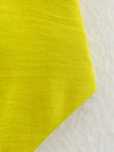Primo piano della trama del tessuto di cotone giallo brillante che mostra il materiale spesso