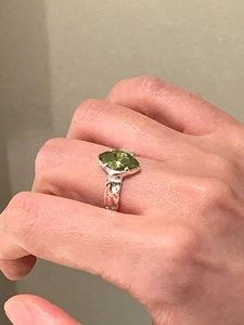 Detail of 925 silver ring with irregular texture and olive green marquise zircon stone