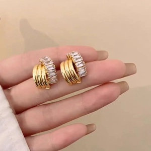 Detail of gold zircon earrings with double-row rectangular crystals held in hand