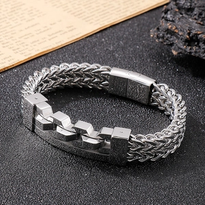 Macro view of men's titanium steel bracelet showing wheat chain and mechanical buckle