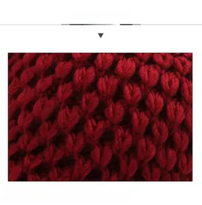 Close-up of thick red knitted fabric with soft rhombus texture for winter warmth