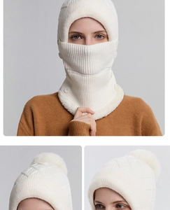Dettaglio della sciarpa con cappuccio in maglia bianca con pompon e bottone laterale