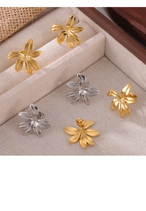Detail of floral petal earrings in gold and silver finish on textured jewelry box lining