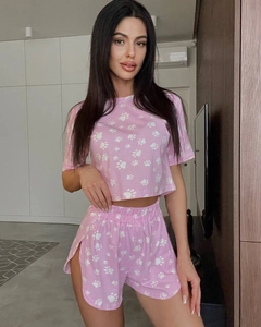 Close-up of pink pajamas set with white cat paw prints and drawstring side-slit shorts