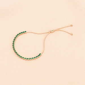 Dettaglio del bracciale tennis dorato regolabile con pietre di zircone verde brillante