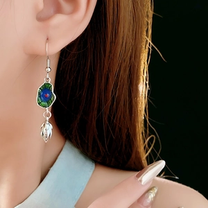 Detail of silver lotus earrings with colorful enamel petals worn on model