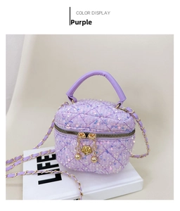 Detailed macro view of purple sequin quilted handbag with gold floral zipper charms