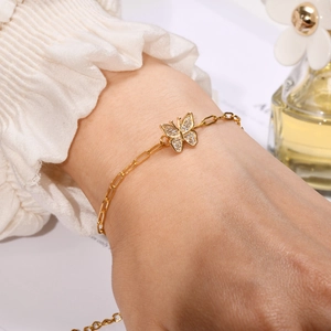 Close-up of a delicate 18K gold butterfly bracelet with pavé cubic zirconia on wrist