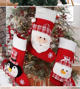 Close-up of knit Christmas stockings with Santa and snowman on a decorated tree