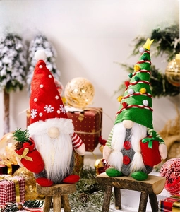 Close-up of red and green Christmas gnomes featuring plush hats and holiday gift props