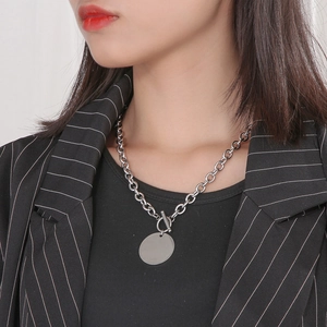 Close-up of polished titanium steel O-chain necklace with round disc pendant and OT clasp
