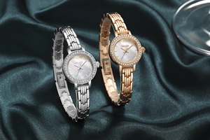 Detailed macro of gold and silver ladies watches with crystal bezels and metal straps