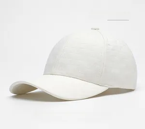 Detailed view of off-white baseball cap with embossed M pattern and stiff wide brim