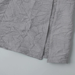 Détail macro du tissu gris plissé et des coutures fines sur la robe élégante