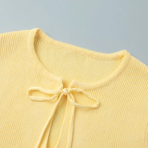 Detail of light yellow ribbed knit neckline with a delicate center bow tie decoration