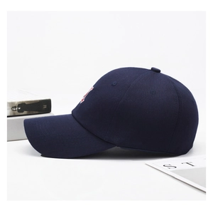 Detail of dark blue cotton baseball cap with red and white embroidery and curved brim