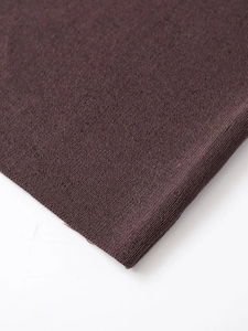 Close-up of the dark brown fine knit fabric texture with a seamless flat stitch pattern