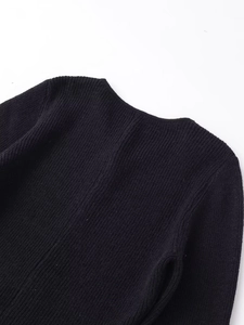 Detail of black rib-knit fabric showing the neck seam and high-quality stitching texture