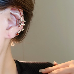 Detail of silver snake ear cuff featuring two red teardrop zircon stones on a model