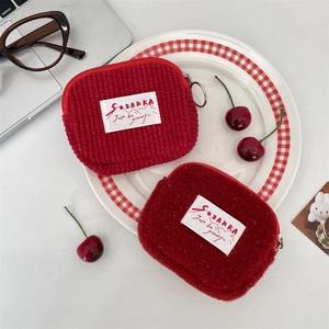 Macro detail of red plush and corduroy mini storage pouches for coins and earphones
