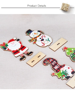 Close-up of wooden Christmas ornaments featuring Santa, snowman and festive JOY text