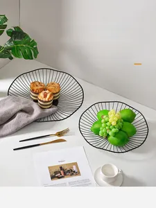 Detail of two black wire mesh fruit baskets with wavy edges in a Nordic minimalist setting