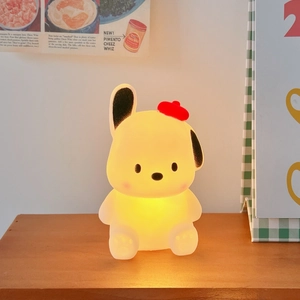Close-up of a cartoon puppy night light with red beret emitting warm yellow light