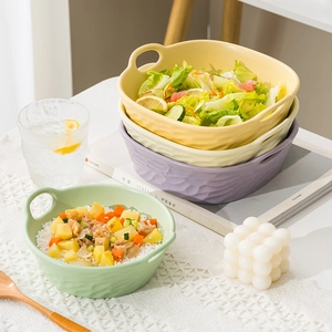 Three colorful ceramic bowls with double handles for salad and cereal in natural light