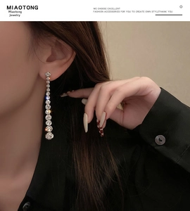 Detail view of elegant silver drop earrings with sparkling rhinestones on a female model