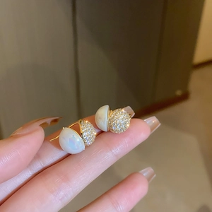 Detail shot of the gold and pearl earring with sparkling diamond pave finish