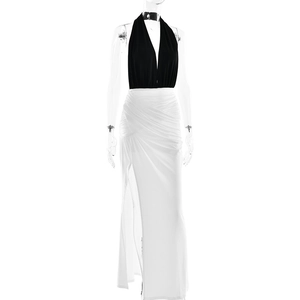 Détail du haut dos nu noir et de la jupe fendue plissée blanche d'une robe longue