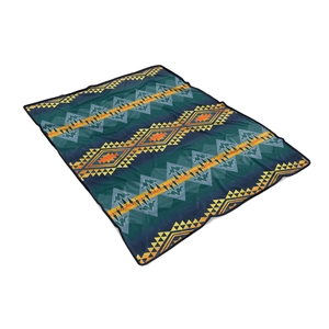 Detail shot of navy blue tribal flannel blanket with orange geometric patterns and lockstitch