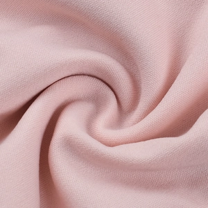 Macro view of pink tweed fabric texture showing soft woven pattern and smooth drape detail