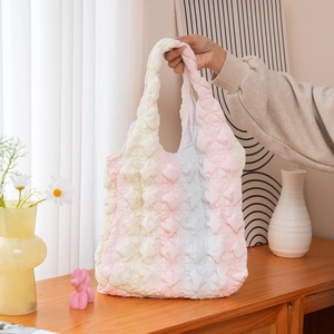 Gros plan du sac cabas plissé pastel montrant la texture douce du tissu à bulles 3D