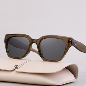 Chic dark green oversized cat-eye sunglasses with polarized gray lenses on a leather case