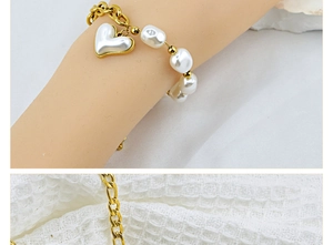 Close-up of a chunky gold bracelet featuring a large heart pendant and irregular pearls