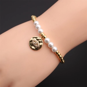 Bracciale elastico con perline dorate e perle bianche e ciondolo occhio del male con zirconi