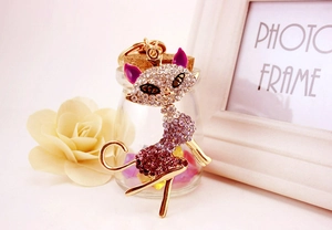 Detail of pink crystal cat keychain with gold rhinestones and decorative accessories