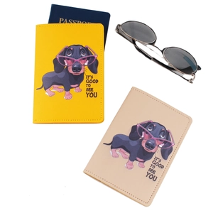 Detail view of yellow and beige leather passport holders with printed dachshund design