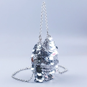 Macro shot of silver sequin chain bag with reflective circular metallic discs and strap