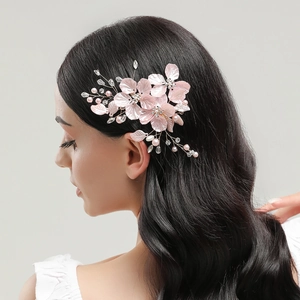 Exquisite bridal hair clip with pink shell flowers, pearls, and crystals on a model