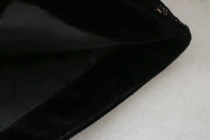 Gros plan sur la texture velours de soie noire et la doublure lisse du haut de luxe
